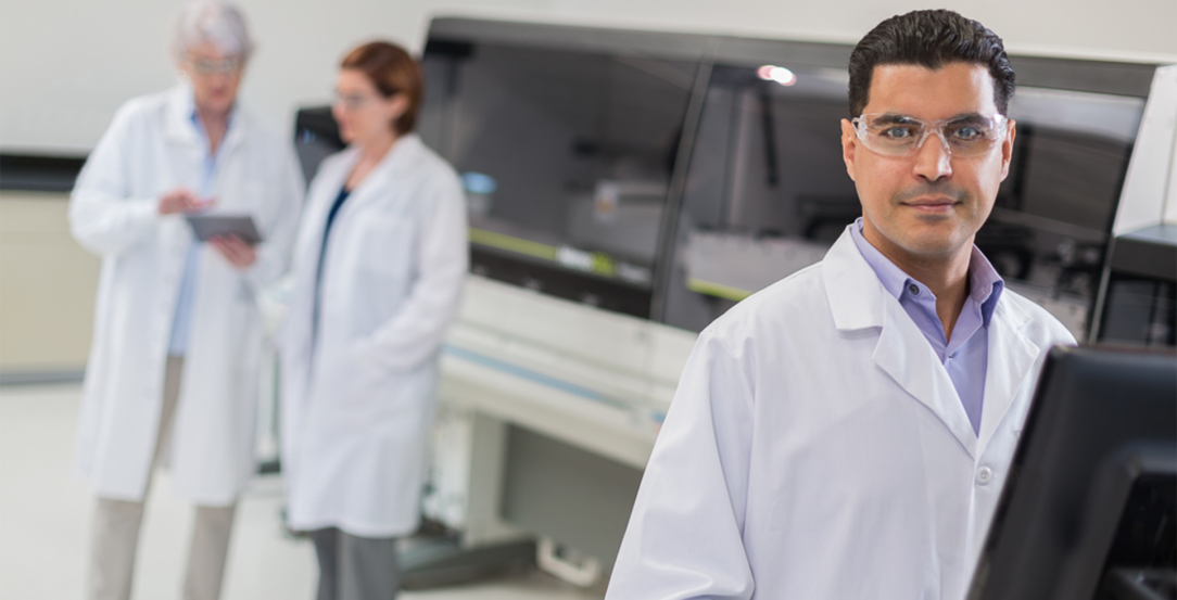 Laboratorian standing infront of computer with Hemocell Specialized Automation in the background